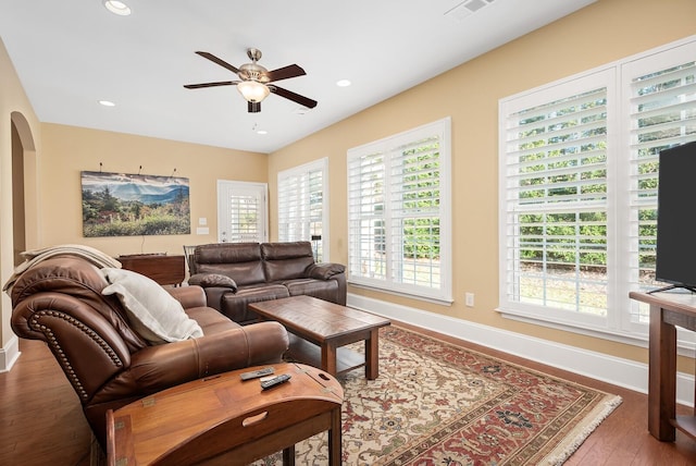 living room featuring wood-type flooring and ceiling fan