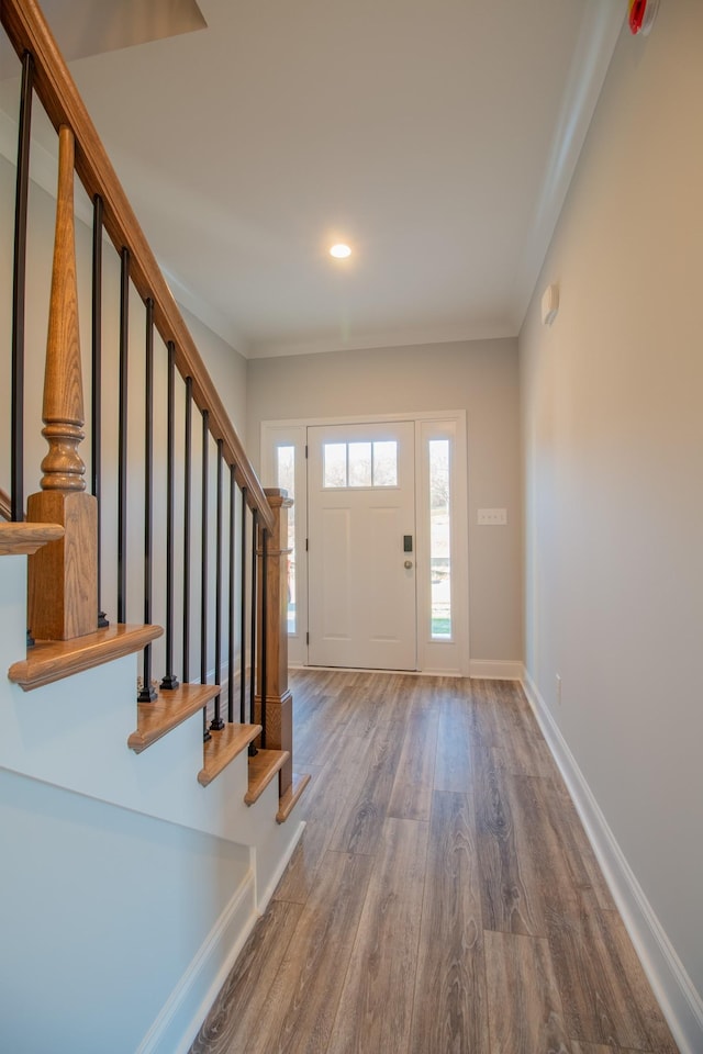 entrance foyer with hardwood / wood-style flooring and crown molding