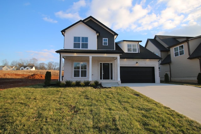 view of front of house with covered porch, a garage, and a front lawn