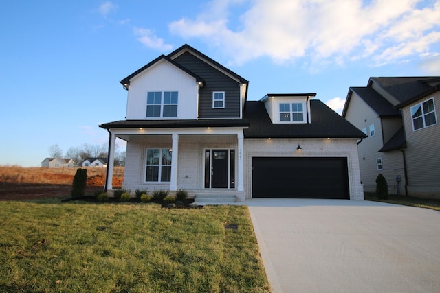 view of front of house featuring covered porch, a garage, and a front yard