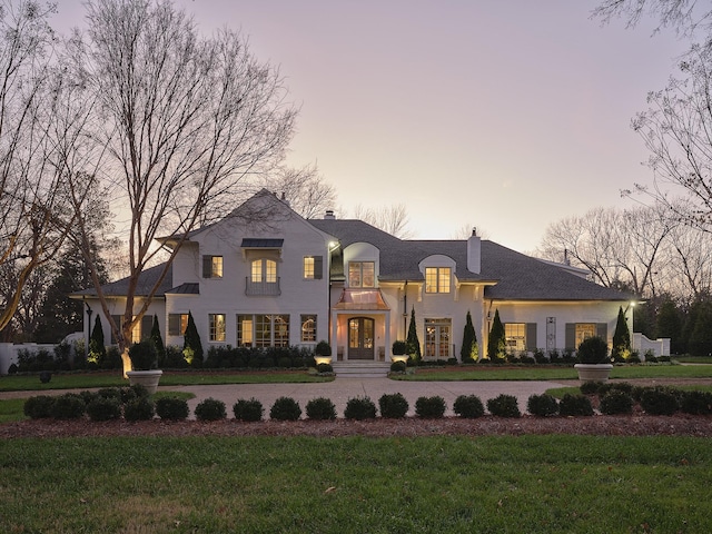 french country style house with a yard and french doors