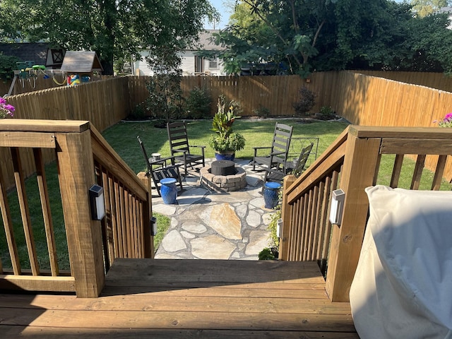 wooden deck with a patio, a yard, an outdoor fire pit, and grilling area