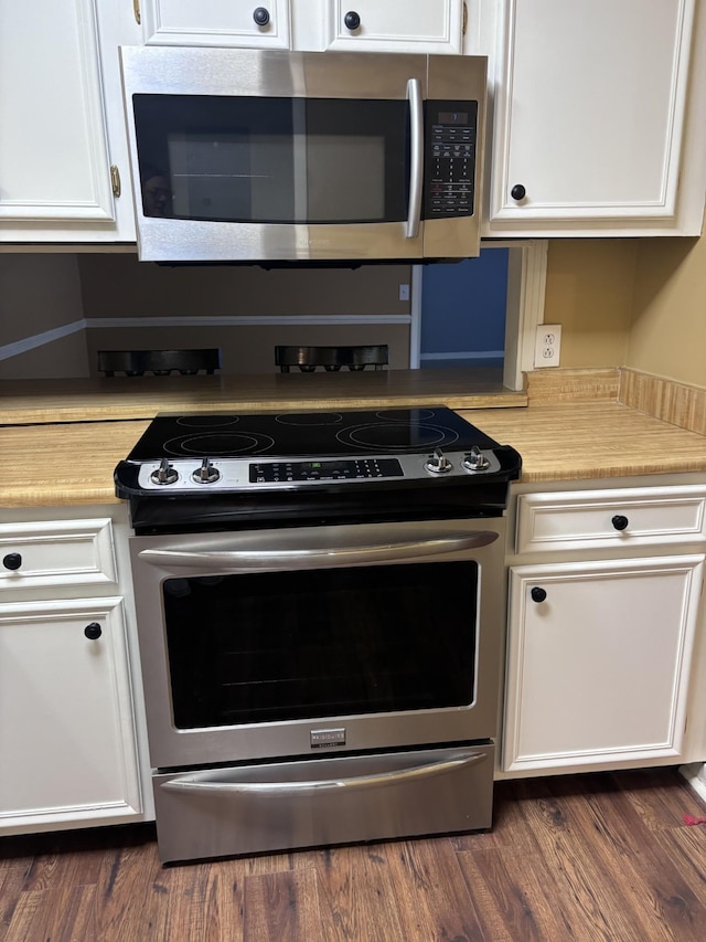 kitchen with white cabinetry, dark wood-type flooring, and appliances with stainless steel finishes