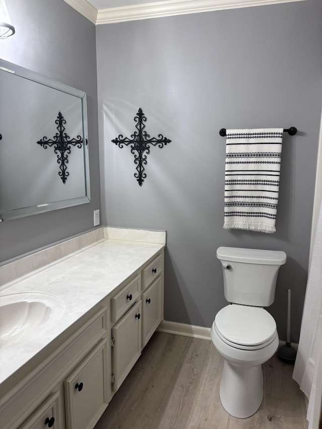 bathroom featuring vanity, hardwood / wood-style flooring, toilet, and crown molding