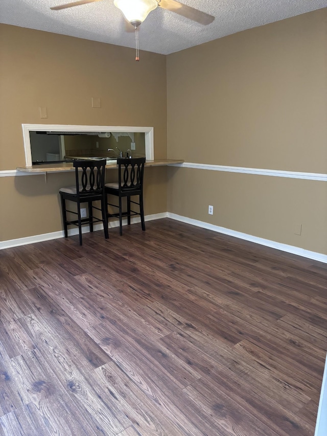 dining area featuring a textured ceiling, dark hardwood / wood-style floors, and ceiling fan