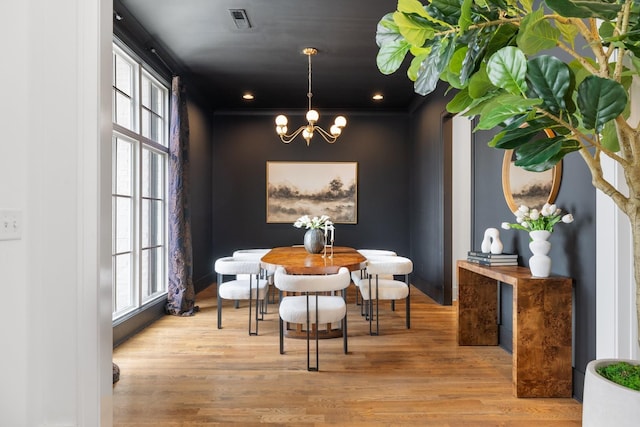 dining space with an inviting chandelier and light hardwood / wood-style flooring