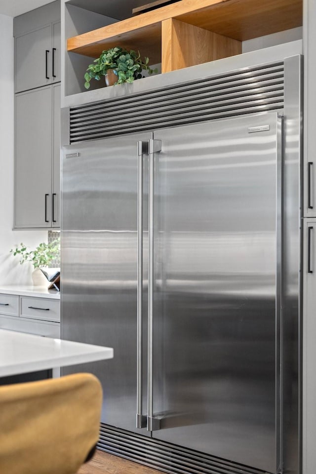 kitchen featuring stainless steel built in refrigerator and gray cabinets