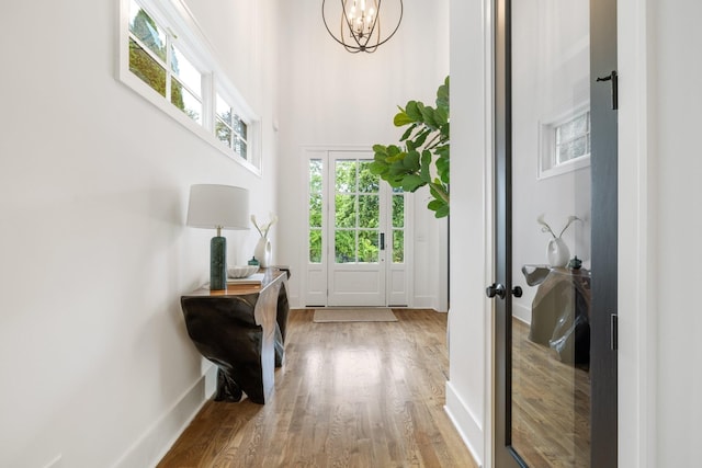 doorway with hardwood / wood-style floors and a chandelier