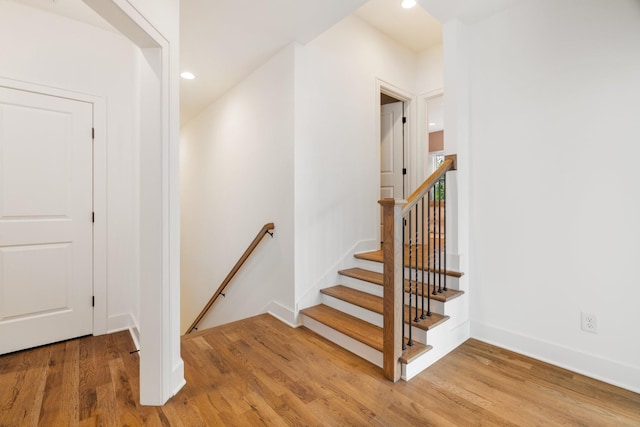 staircase with hardwood / wood-style floors