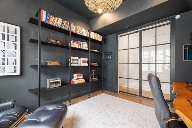 office space with built in shelves and hardwood / wood-style flooring