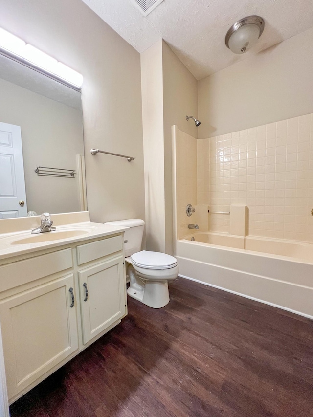 full bathroom featuring shower / bath combination, vanity, a textured ceiling, wood-type flooring, and toilet