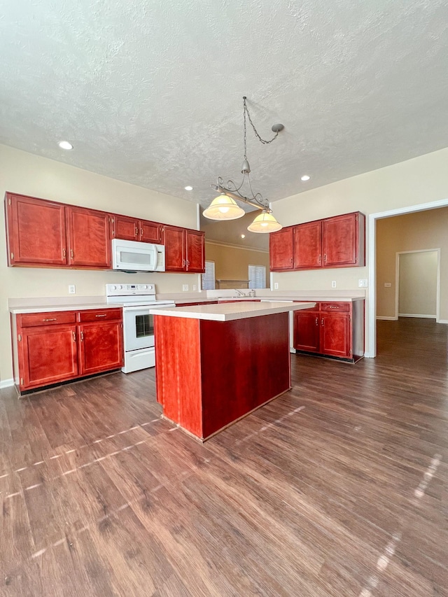 kitchen with a center island, dark hardwood / wood-style floors, pendant lighting, a textured ceiling, and white appliances