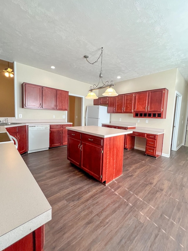 kitchen featuring white appliances, hanging light fixtures, ceiling fan, a textured ceiling, and a kitchen island