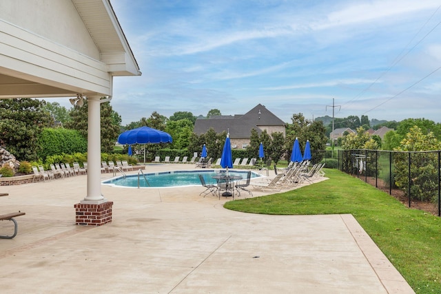 view of pool with a lawn and a patio