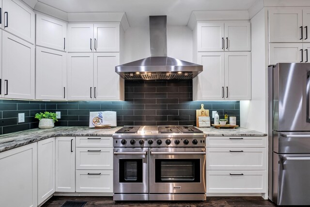 kitchen with wall chimney exhaust hood, white cabinetry, and appliances with stainless steel finishes