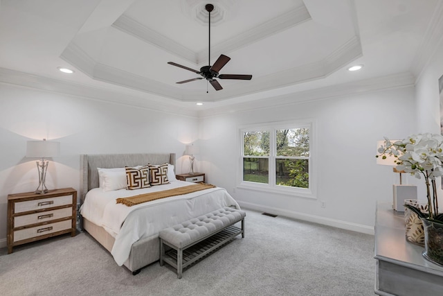 carpeted bedroom with a raised ceiling, ceiling fan, and crown molding