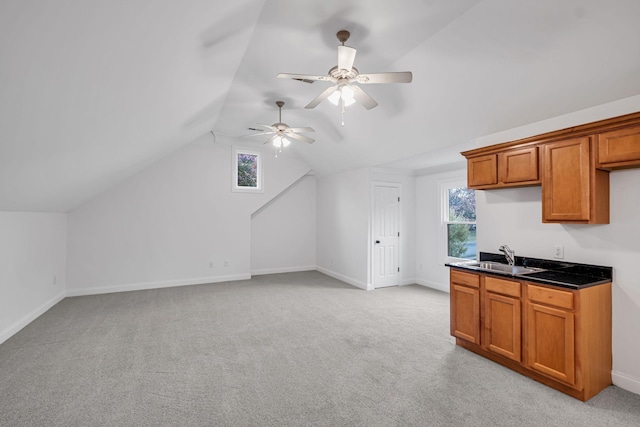 kitchen featuring ceiling fan, sink, a healthy amount of sunlight, and vaulted ceiling