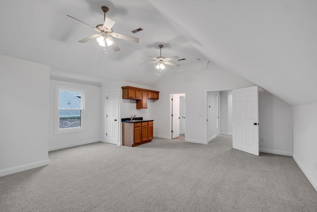 unfurnished living room with ceiling fan, sink, light carpet, and vaulted ceiling