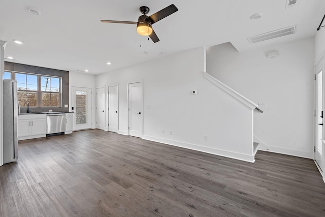 unfurnished living room featuring ceiling fan, dark hardwood / wood-style floors, and sink