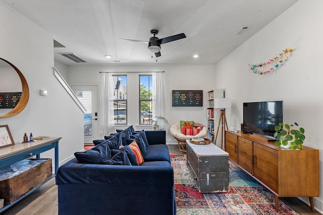 living room featuring ceiling fan and dark hardwood / wood-style floors