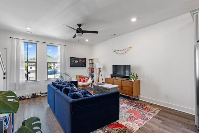 living room featuring ceiling fan and dark wood-type flooring