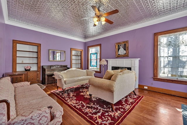 living room with ceiling fan, crown molding, and brick ceiling