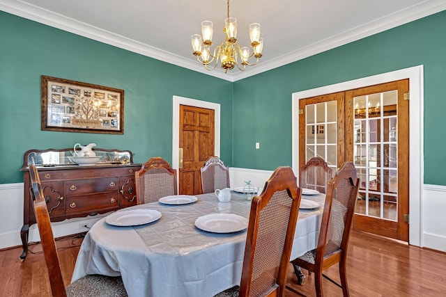 dining room featuring a chandelier, wood-type flooring, french doors, and crown molding