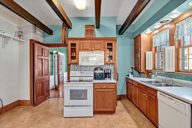 kitchen with a textured ceiling, white appliances, tasteful backsplash, and sink