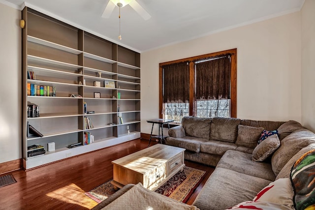 living room featuring built in shelves, ceiling fan, hardwood / wood-style floors, and ornamental molding