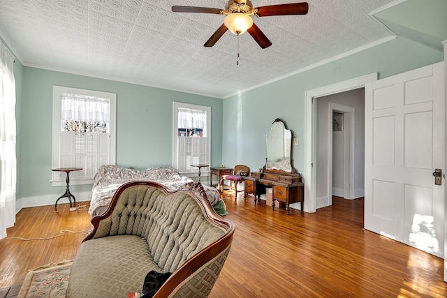 living room featuring a wealth of natural light, ceiling fan, wood-type flooring, and ornamental molding