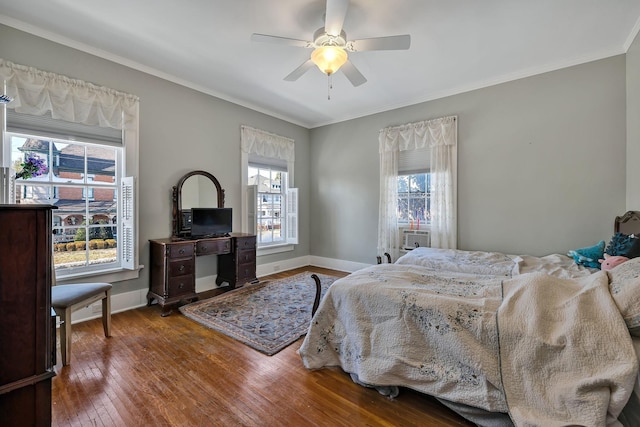 bedroom with multiple windows, ceiling fan, and hardwood / wood-style flooring