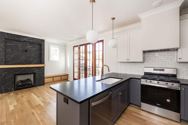 kitchen with stainless steel appliances, kitchen peninsula, sink, and white cabinets