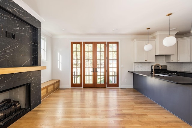 kitchen with pendant lighting, stainless steel stove, a wealth of natural light, and white cabinets