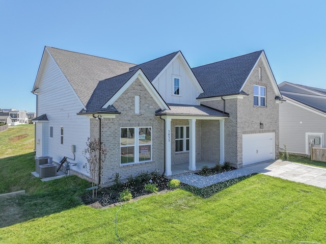 view of front of home with covered porch, a front yard, and a garage