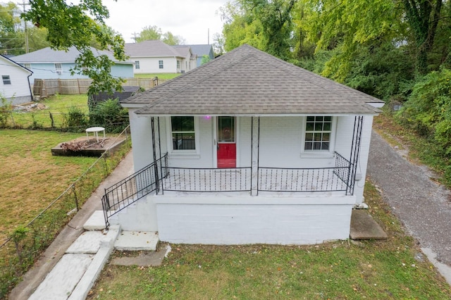 view of front of house featuring covered porch and a front lawn