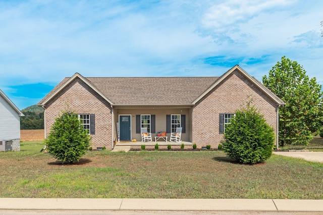 ranch-style home featuring central air condition unit, a front lawn, and covered porch