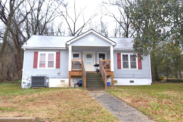 view of front of property with central AC and a front lawn