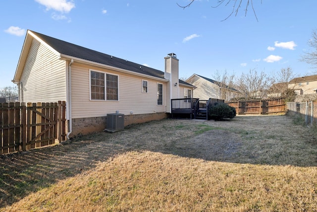 rear view of house featuring a yard, central air condition unit, and a wooden deck