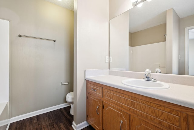 bathroom featuring hardwood / wood-style floors, vanity, a textured ceiling, and toilet