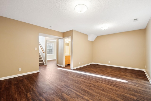 empty room featuring dark hardwood / wood-style flooring and a textured ceiling