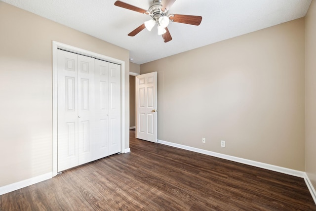 unfurnished bedroom with dark hardwood / wood-style flooring, a closet, and ceiling fan