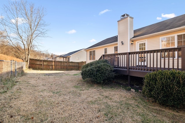 back of house with a deck and a yard