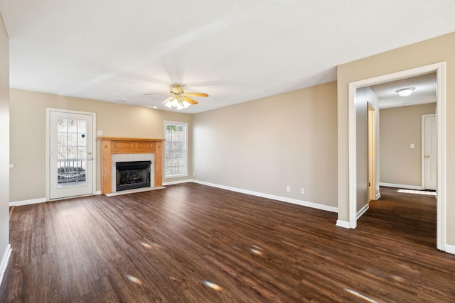 unfurnished living room with a textured ceiling, dark hardwood / wood-style flooring, and ceiling fan