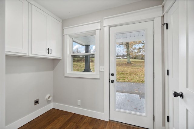 washroom featuring dark wood-type flooring, cabinets, and hookup for an electric dryer