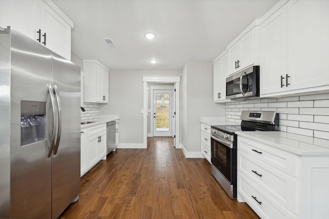 kitchen featuring backsplash, dark hardwood / wood-style flooring, white cabinets, and stainless steel appliances