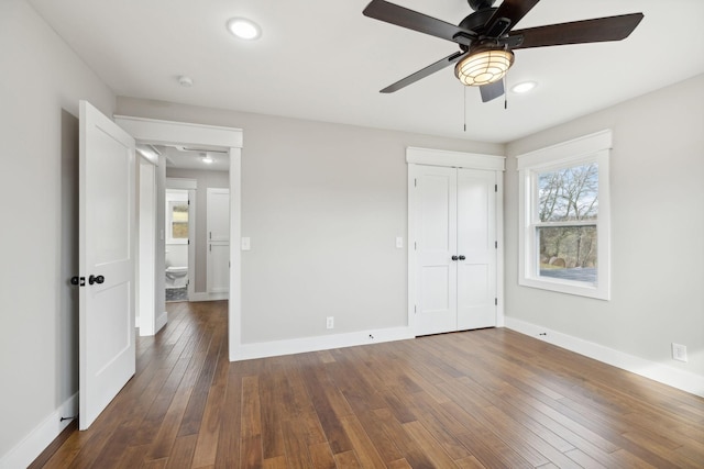 unfurnished bedroom featuring ceiling fan, dark wood-type flooring, and a closet