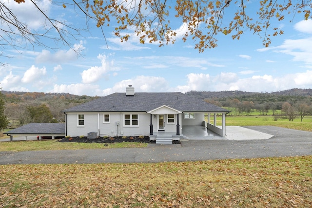 ranch-style house with a front yard, central AC unit, and a carport