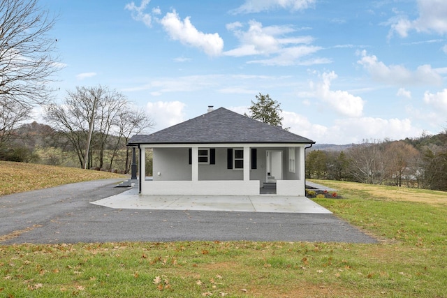 exterior space with a porch and a front yard