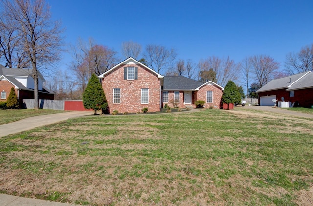 traditional-style house featuring a garage, brick siding, and a front yard