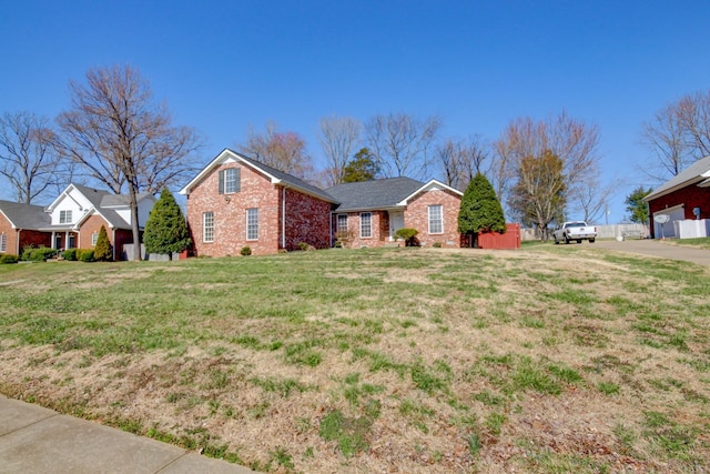 ranch-style house with a front yard and brick siding